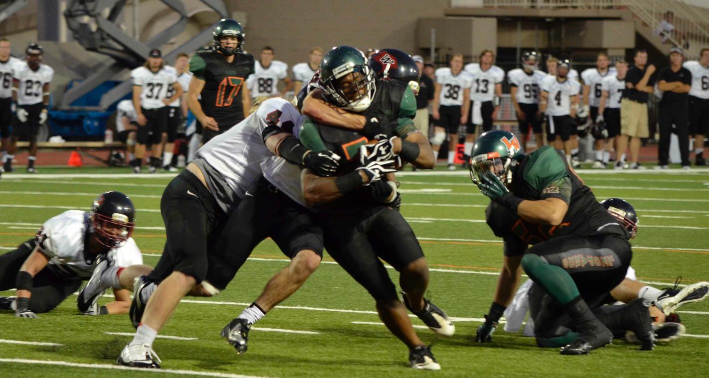 Matt Biggers carries a pair of Whitworth defenders into the end zone for a second quarter touchdown